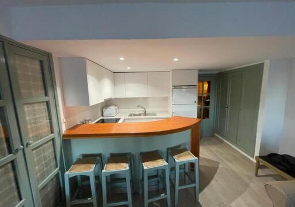 a kitchen with a bar with stools and a sink at Apartamento Ameto en la plaza Pradollano"Junto al telecabina Borreguiles" in Sierra Nevada