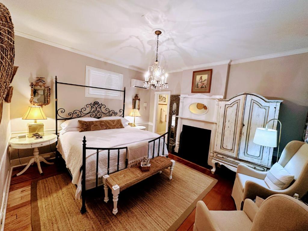 1 dormitorio con 1 cama, 1 silla y chimenea en Bijou Boutique Inn, en Charleston