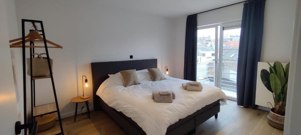 a bedroom with a large bed with two towels on it at Luxueus, ruim appartement op 350m van het strand in Ostend