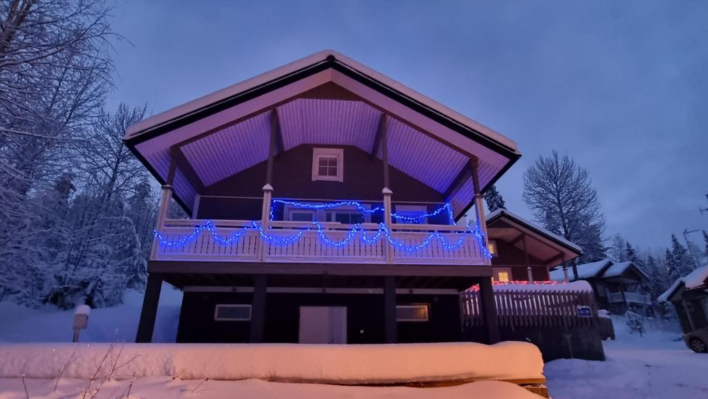 ein Haus mit einem lila Deck im Schnee in der Unterkunft Villa Magnolia 2 Himos in Jämsä