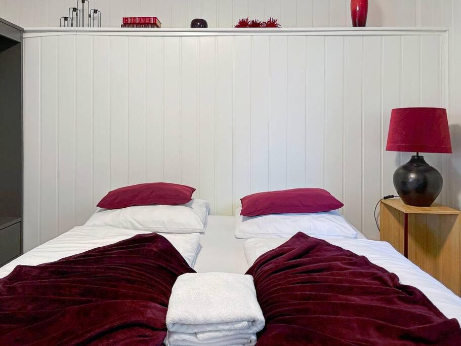 a bedroom with two beds with red and white pillows at Stavanger BnB 4 by Sidd in Stavanger