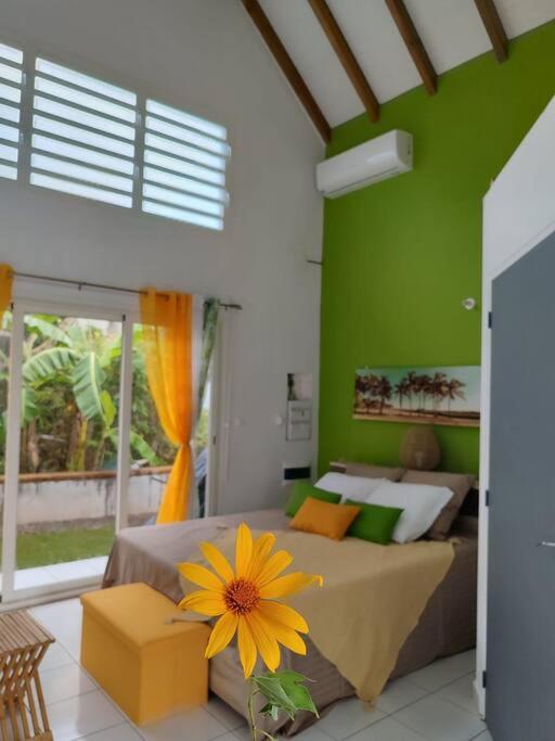 a bedroom with a bed with a yellow flower on it at Jeune Tournesol (Bungalow neuf) in Sainte-Anne