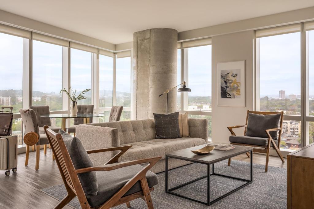 a living room with a couch and chairs and windows at Sonder at Pierce Boston in Boston