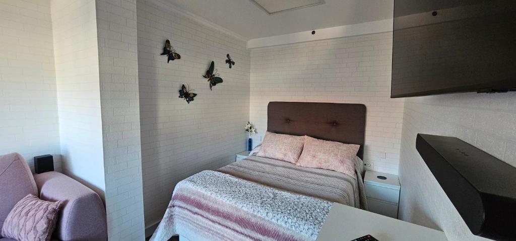 Cette petite chambre comprend un lit avec des draps roses. dans l'établissement Estudio tranquilo cerca del mar., à Puerto de la Cruz