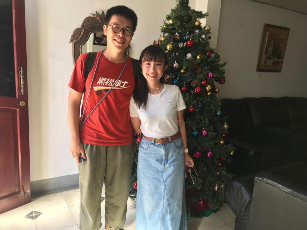 a man and a girl standing in front of a christmas tree at El Callejon Guest House in León