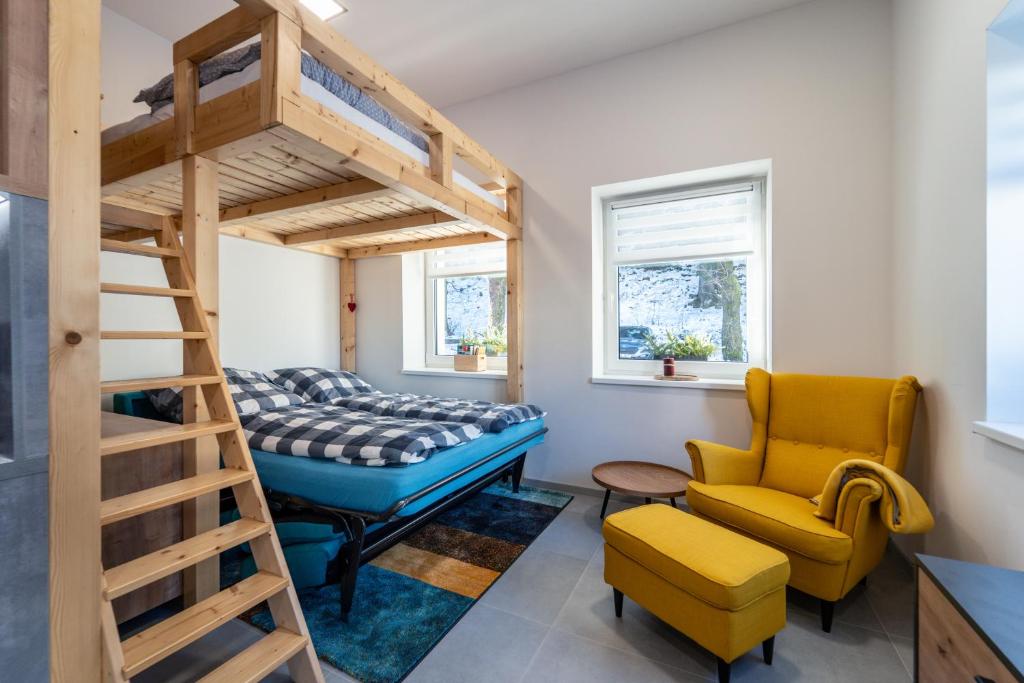 a room with a bunk bed and a chair at Apartmán SPORT in Pernink