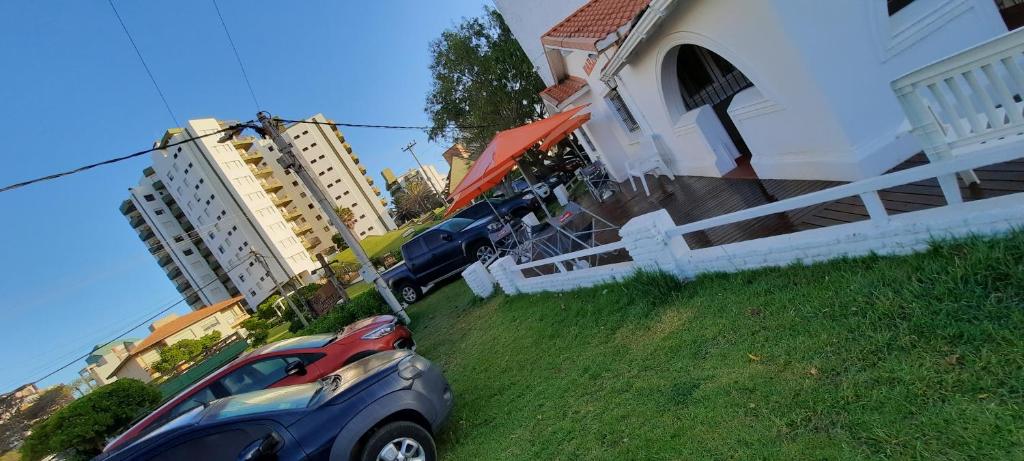 een auto geparkeerd op het gras naast een huis bij Hotel Marino in Villa Gesell