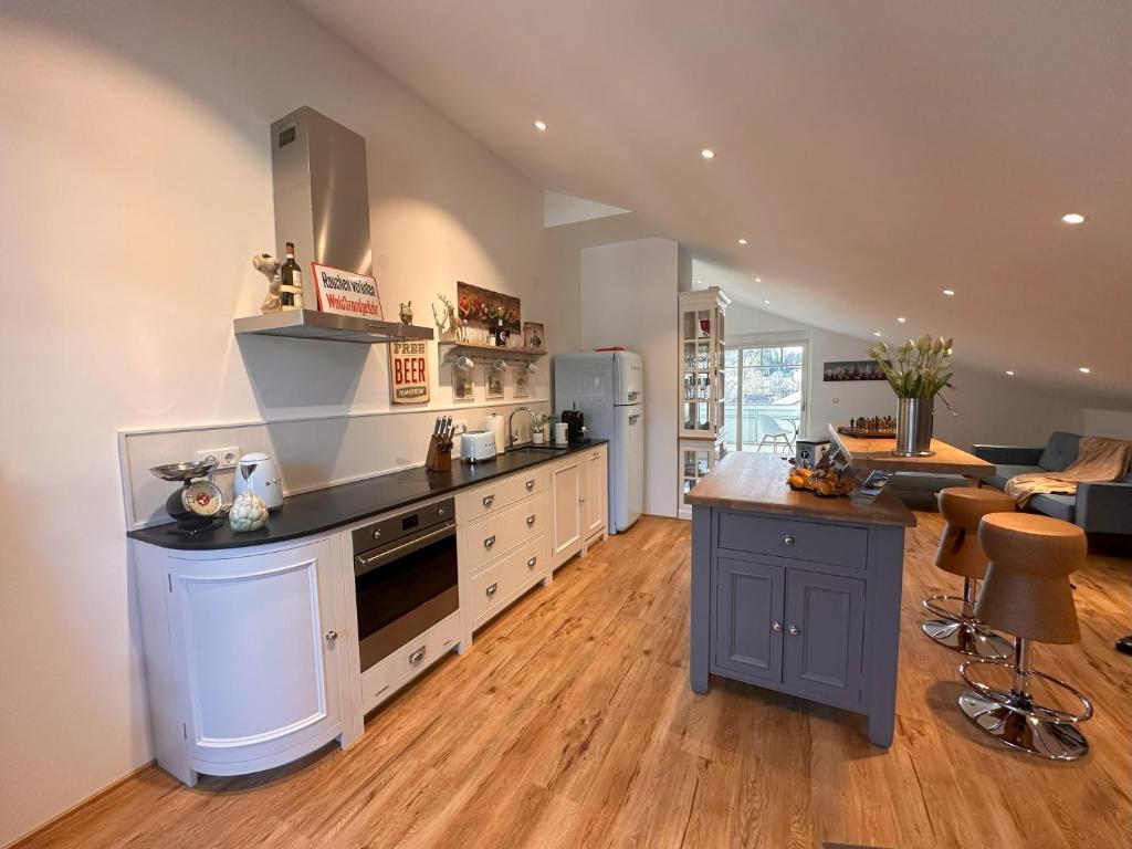 a large kitchen with white cabinets and a counter top at Vaicun Stays - LUXURY APARTMENTS - Apartments mit Blick auf den Tegernsee in Gmund am Tegernsee