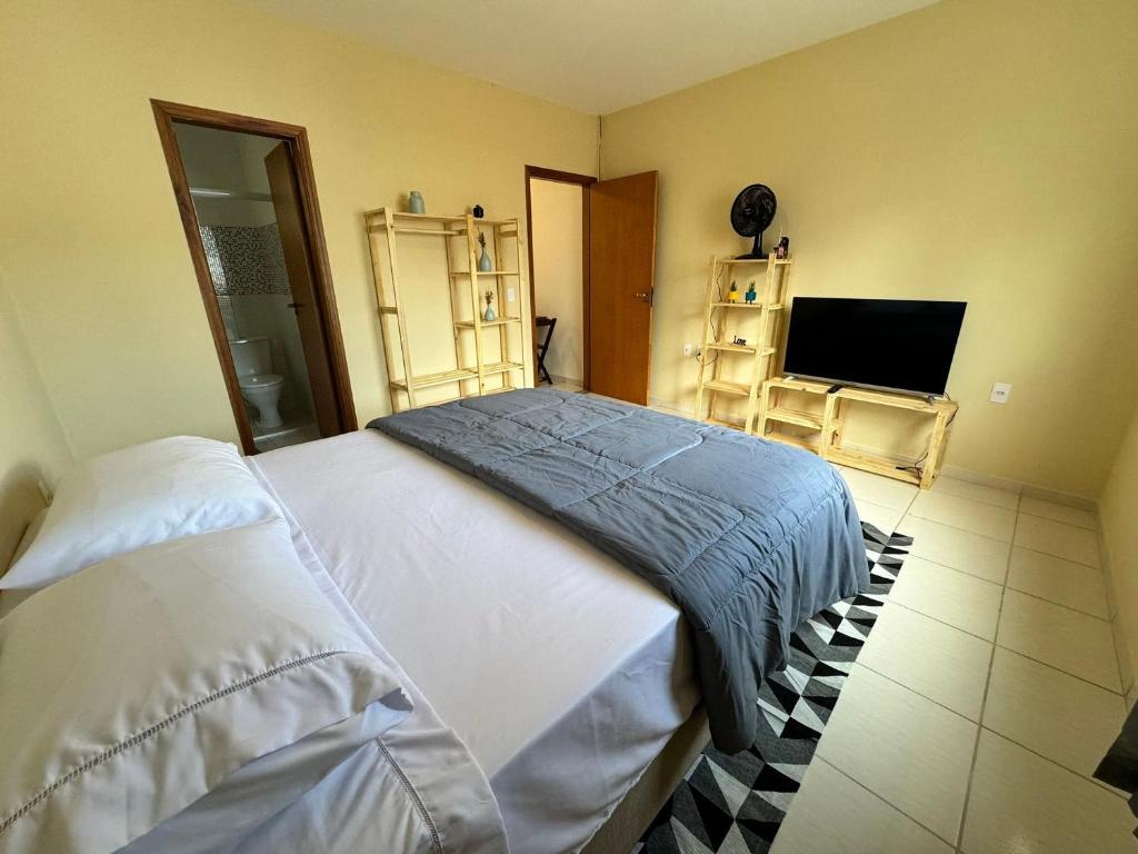a bedroom with two beds and a flat screen tv at Kitnet no coração de Serra Negra in Serra Negra