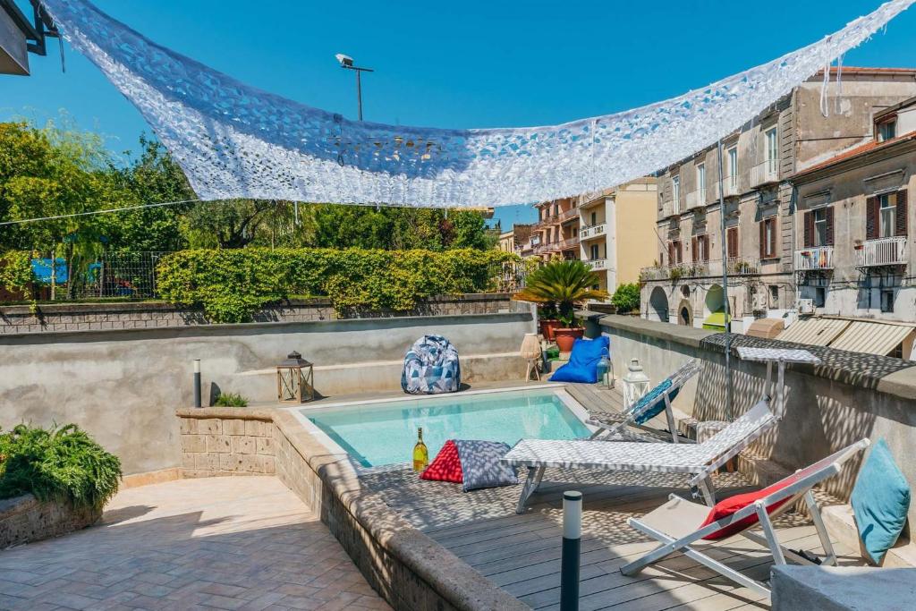 a swimming pool with a table and chairs next to a building at My Exclusive Italy - Spacious Villa with 4 rooms, pool, solarium & garden in Sant'Agnello