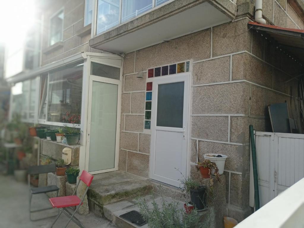 un edificio de ladrillo con una puerta blanca y una ventana en Habitación acogedora en casa de piedra, en Vigo