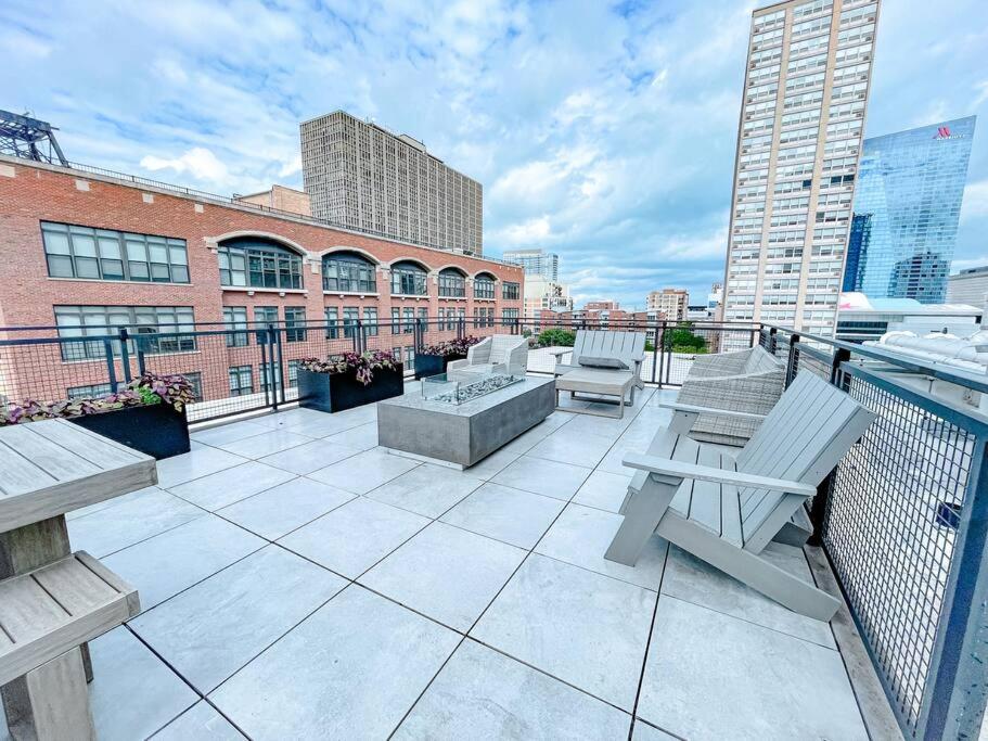 a balcony with chairs and tables on a building at McCormick 2br/2ba Oasis with Optional Parking, Patio, Gym for up to 6 guests in Chicago