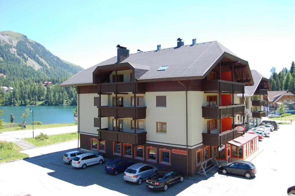 a building with cars parked in front of it at Appartementhaus Turracher Höhe in Turracher Hohe