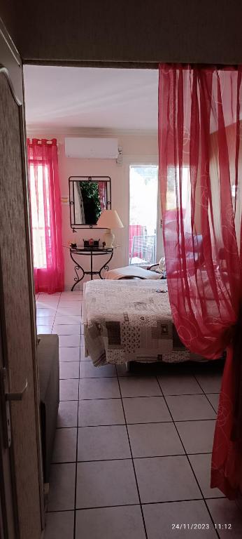 - une chambre avec un lit doté de rideaux rouges dans l'établissement Loratori La Felicadad Cures & Vacances, à Amélie-les-Bains-Palalda
