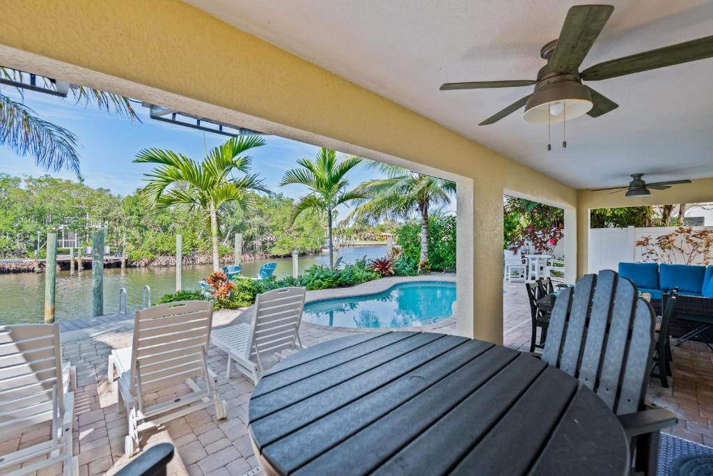 a dining room with a table and chairs and a pool at Paradise on Pine in Anna Maria