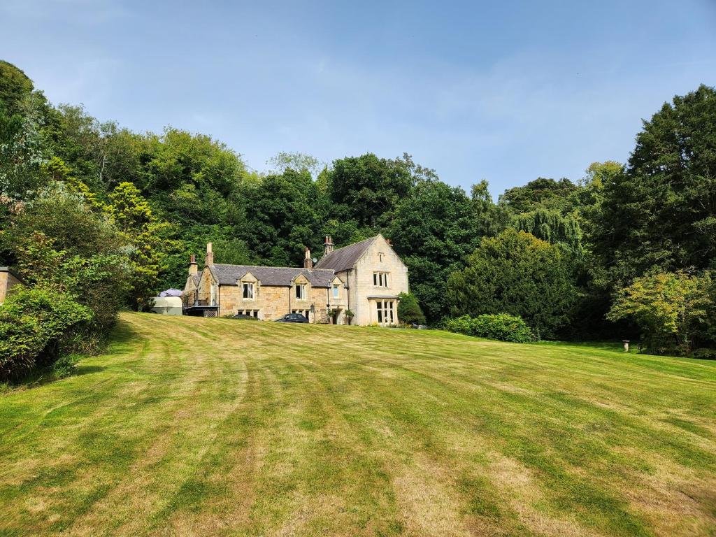 an old house on a large grassy field at Mulgrave Country Cottage in Whitby