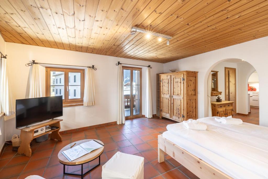 a large bedroom with a large bed and a flat screen tv at Chasina Bagnera in Scuol