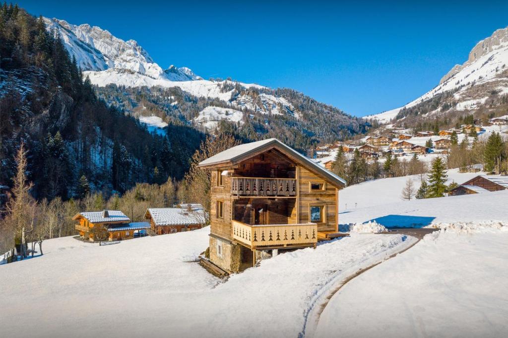 una cabaña de madera en la nieve en las montañas en Le Mazot de La Caillère - OVO Network en La Giettaz