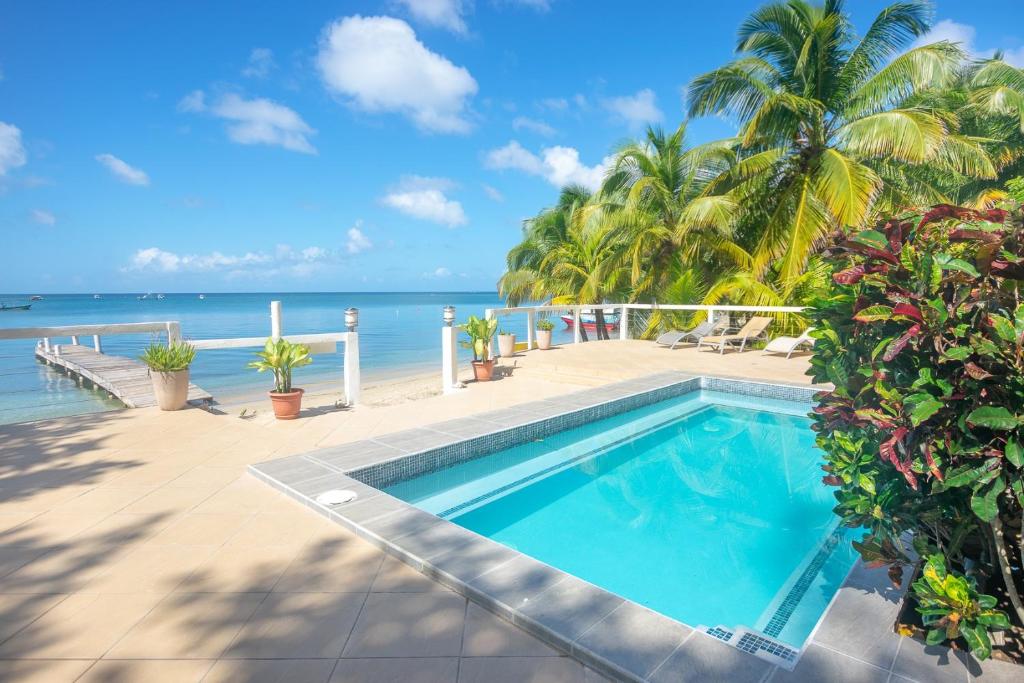 a swimming pool with the ocean in the background at Del Playa #4 - 278851 Condo in West End