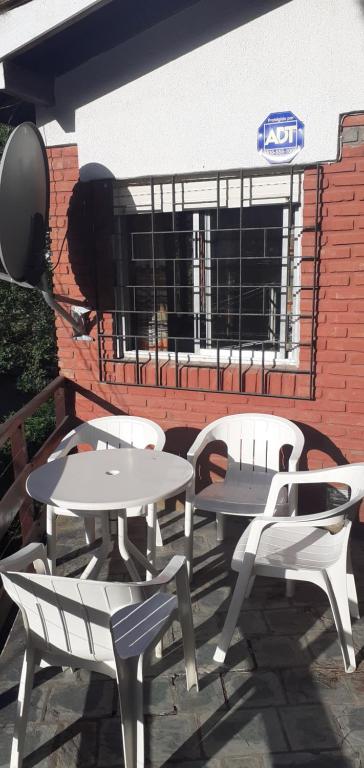 un patio con 2 mesas y sillas frente a un edificio en 9 amigos en Villa Gesell