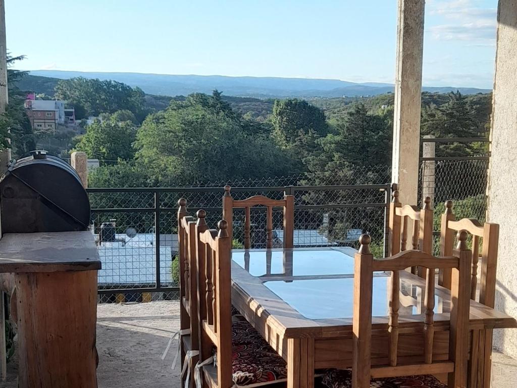 a wooden table and chairs on a balcony at ENCANTO SERRANO in Villa Carlos Paz