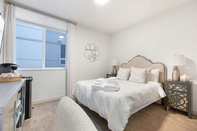 a white bedroom with a bed and a window at The Canal 15A BY Betterstay in Seattle