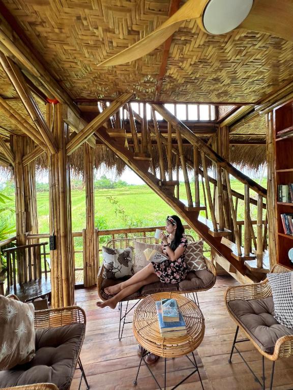 a woman sitting on a couch in a living room at Joseph Agricultural Farm in Ubay