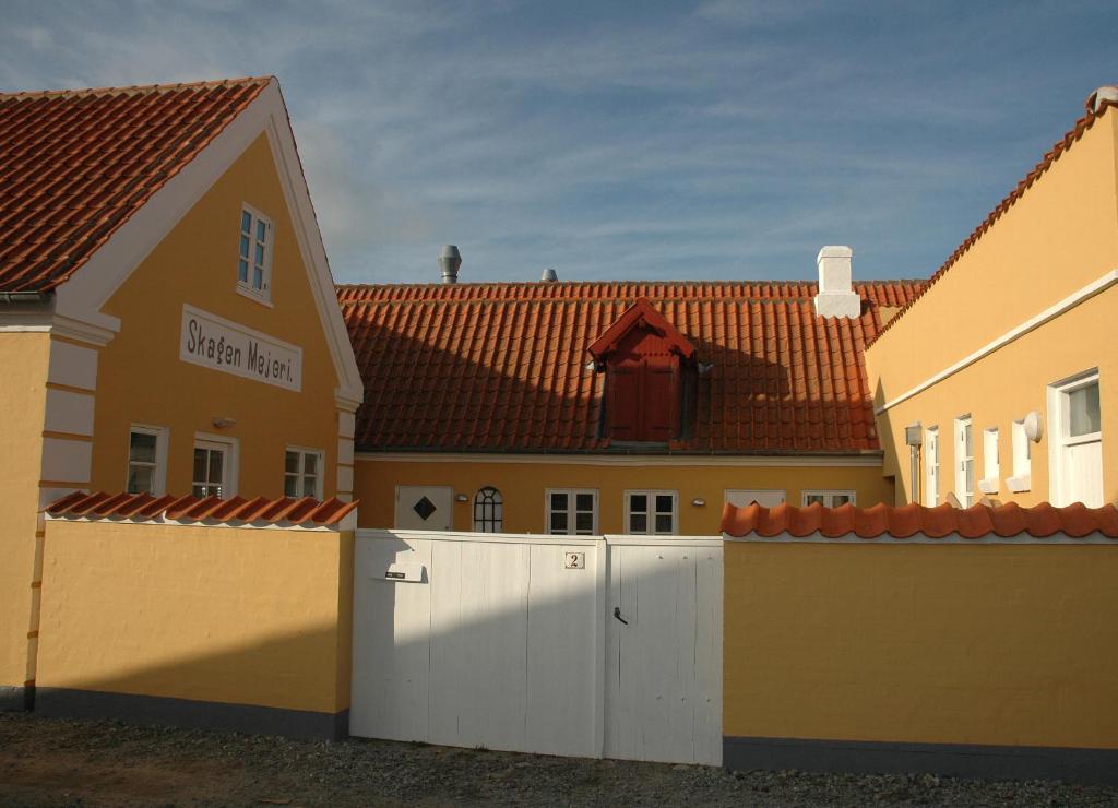 a white fence in front of a building at Skagen City Apartments in Skagen