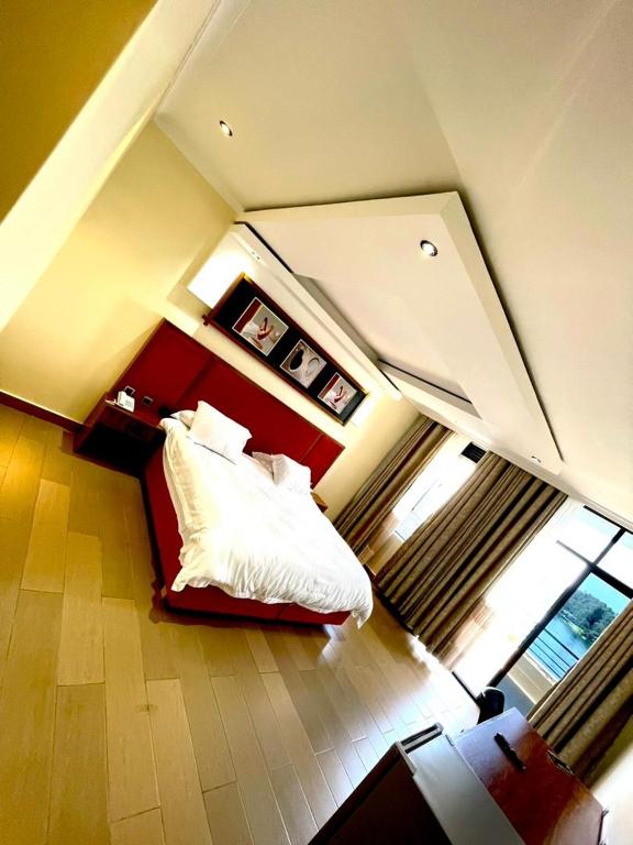a bedroom with a bed with white sheets and pillows at Contemporary Suite in Kibuye