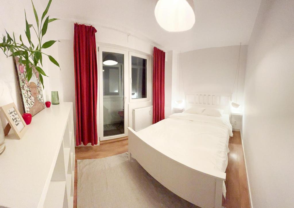 um quarto com uma cama grande e cortinas vermelhas em Lola’s apartament close to city center em Bucareste