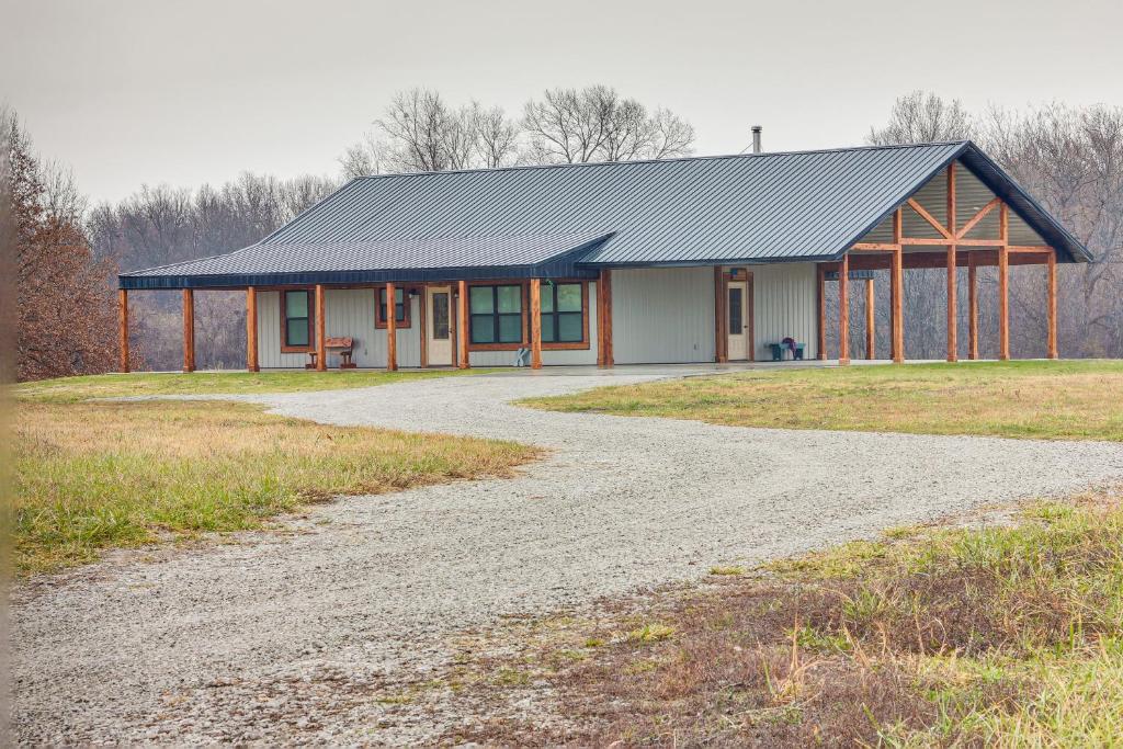 a house with a gravel road in front of it at Rural Drexel Cabin on 30 Acres Unplug and Unwind! in Drexel