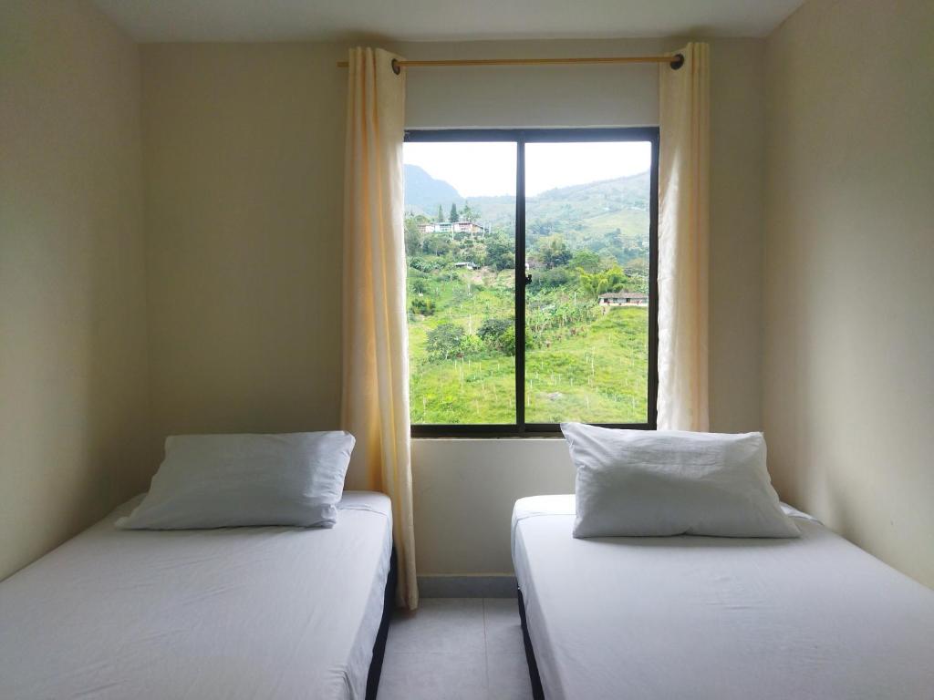 two beds sitting in a room with a window at Canto del rio in Jardin