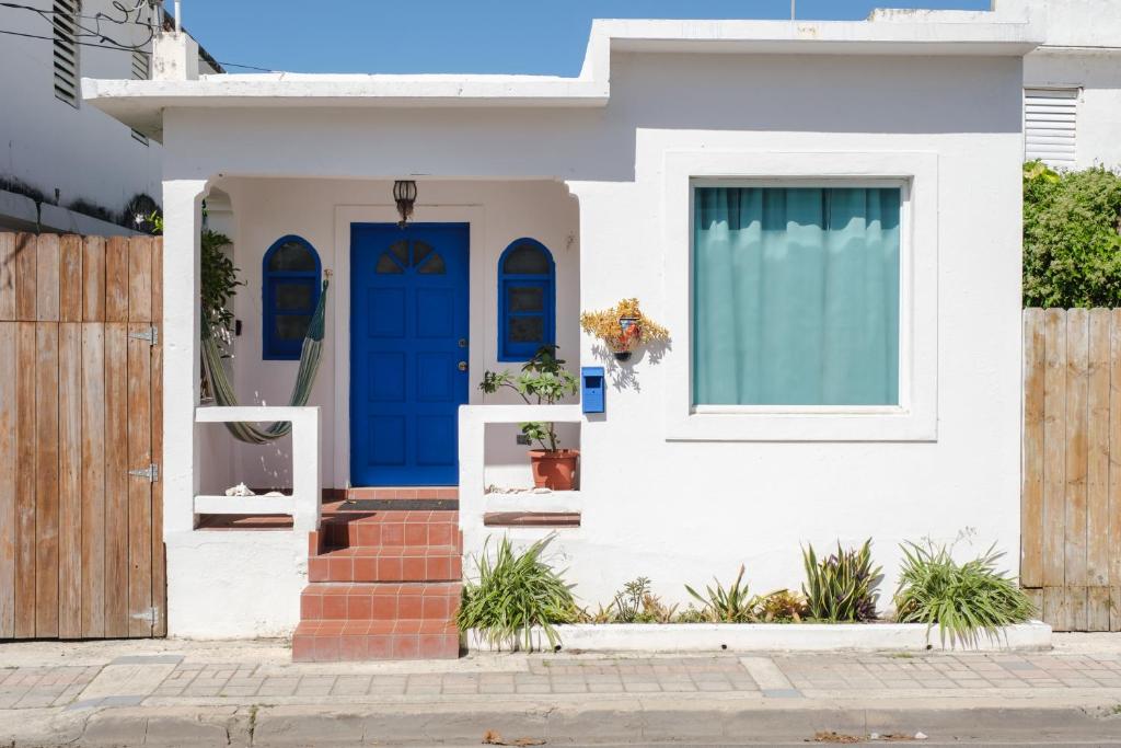 a white house with a blue door at Dream Beach House by Sonsoleá Host in Luquillo