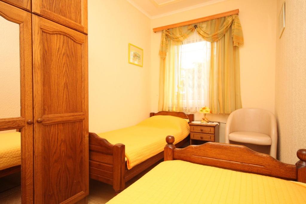 a small bedroom with two beds and a chair at Apartments by the sea Kraj, Pasman - 3460 in Pašman