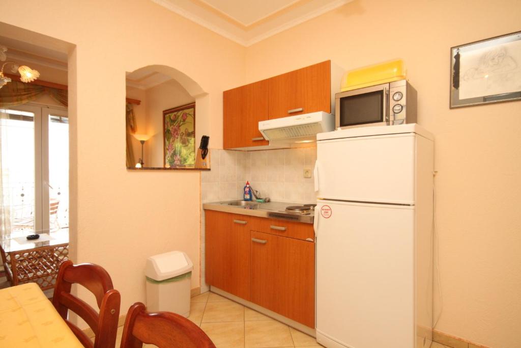 a kitchen with a white refrigerator and a microwave at Apartments by the sea Kraj, Pasman - 3460 in Pašman