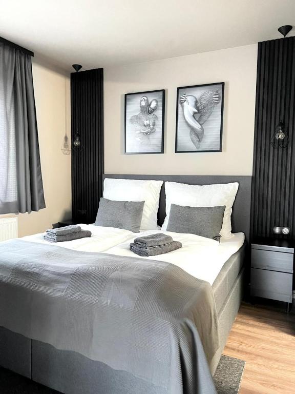 a bedroom with a large bed with three pictures on the wall at The Steakhouse - Guest Rooms in Sankt Johann im Pongau