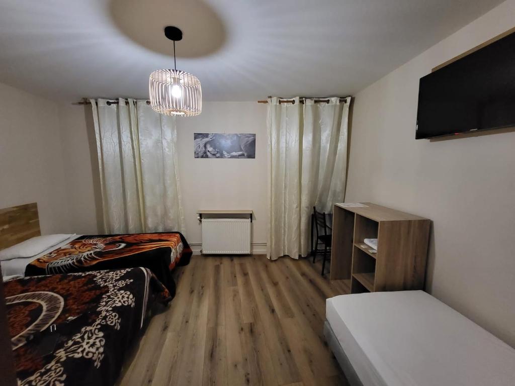 een kamer met 2 bedden en een flatscreen-tv bij HOTEL IN PARIS in Aubervilliers