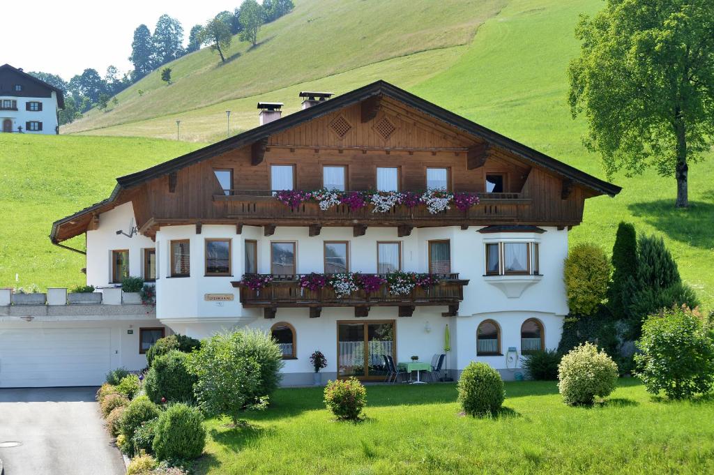 a house with a balcony on a hill at Ferienwohnung Seethaler in Thiersee