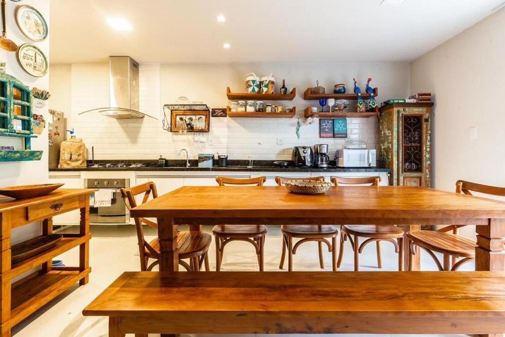a kitchen with a large wooden table and chairs at Casa pé na areia no Tree Bies in Subaúma