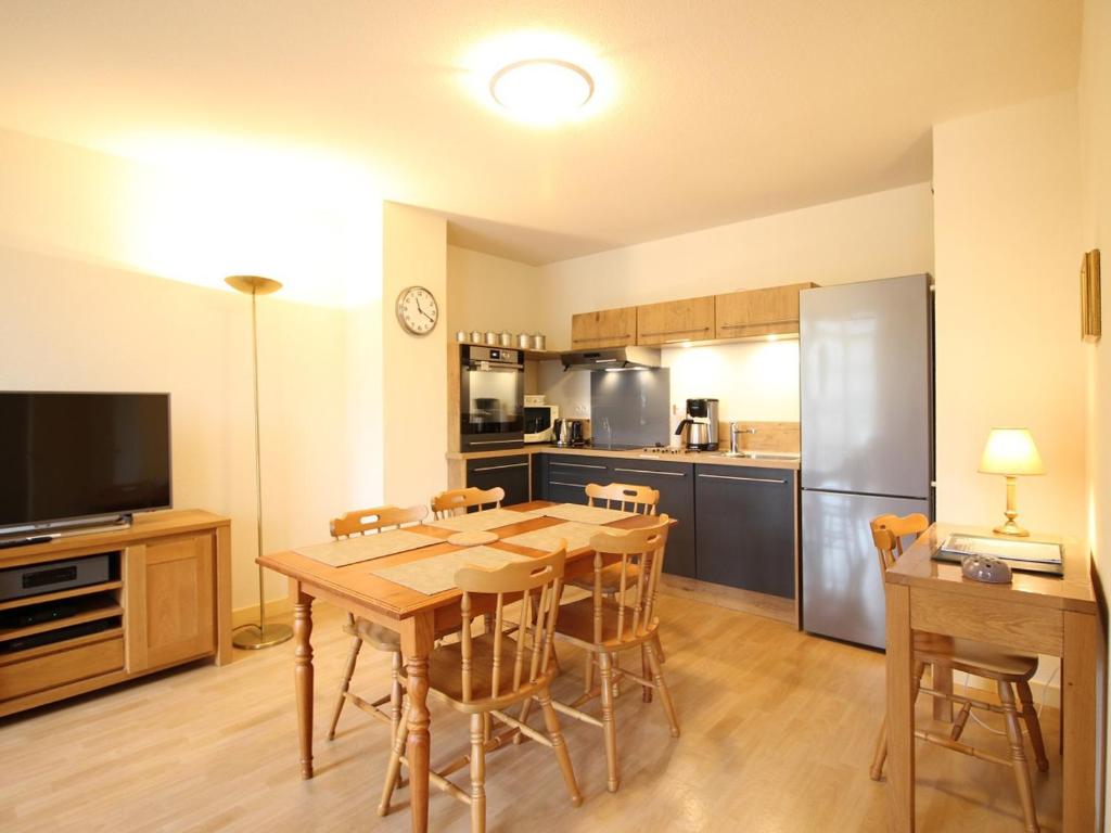eine Küche und ein Esszimmer mit einem Holztisch und Stühlen in der Unterkunft Appartement La Bourboule, 2 pièces, 5 personnes - FR-1-608-56 in La Bourboule