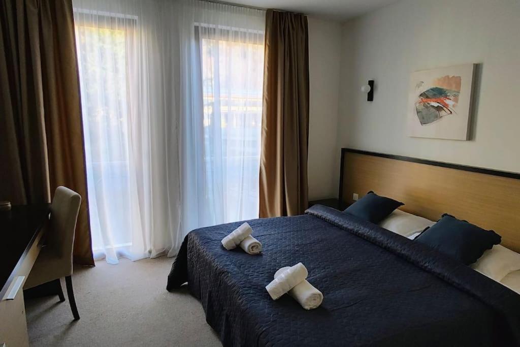 サンダンスキにあるModern 2BDRM in 5* Resort & poolのベッドルーム1室(ベッド1台、タオル2枚付)