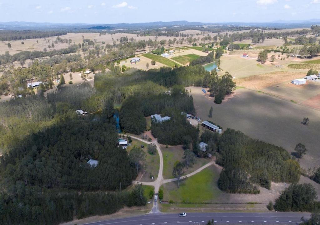 an aerial view of a park with trees and a lake at Sweetacres Hunter Valley in Pokolbin