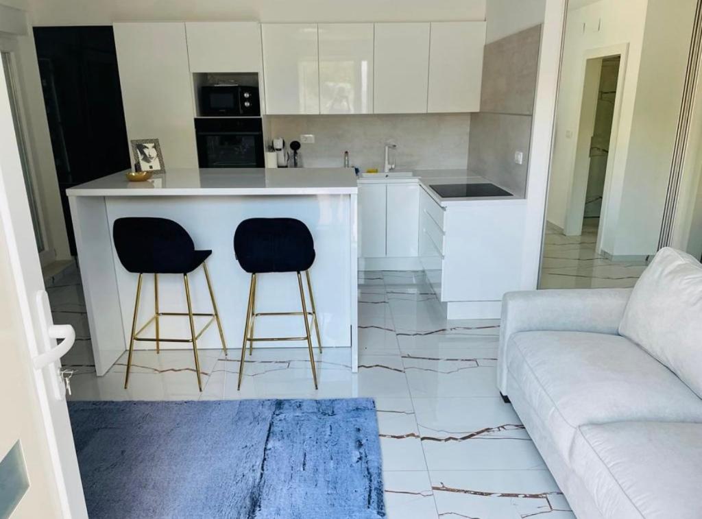 a kitchen with a couch and two bar stools at Elite rooms Split - FREE PARKING in Split