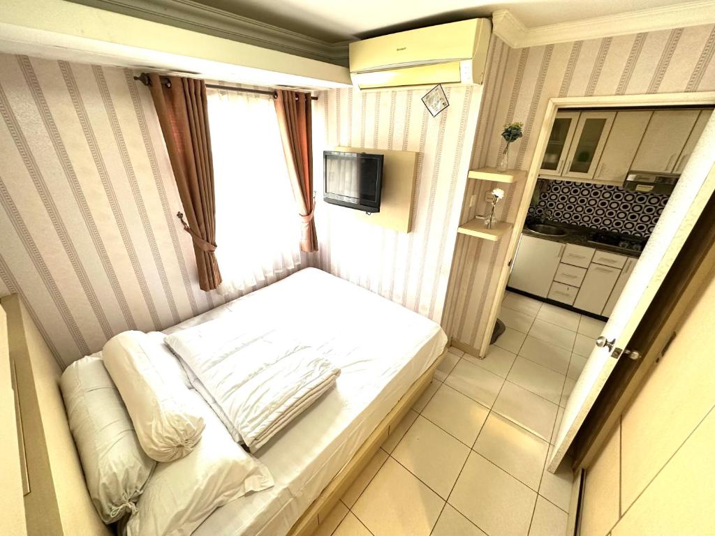 Kleines Zimmer mit einem Bett und einer Küche in der Unterkunft 2 Bedrooms Apartment Strategic Location Affordable for All in Jakarta