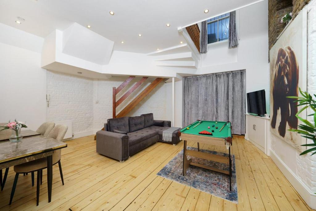 a living room with a couch and a pool table at Modern 4-bedroom Apartment in Fulham, London in London