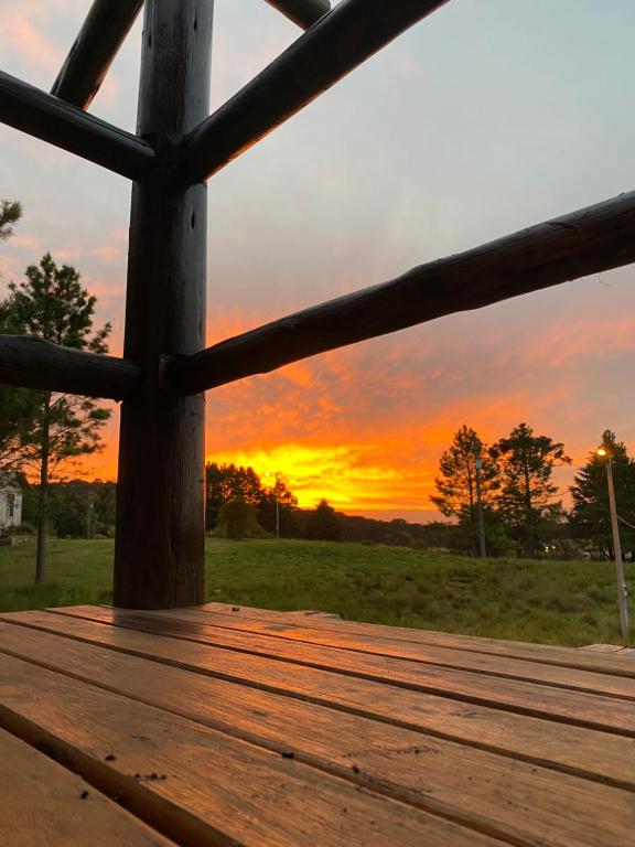 a wooden deck with a sunset in the background at Morada das Estrelas in Cambara do Sul