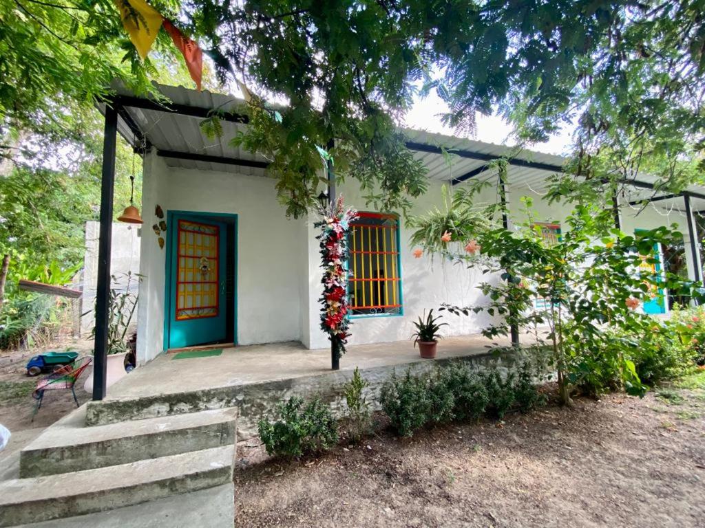 a house with a blue door and a tree at Apartaestudio Villa Mary-Aguachica in Aguachica