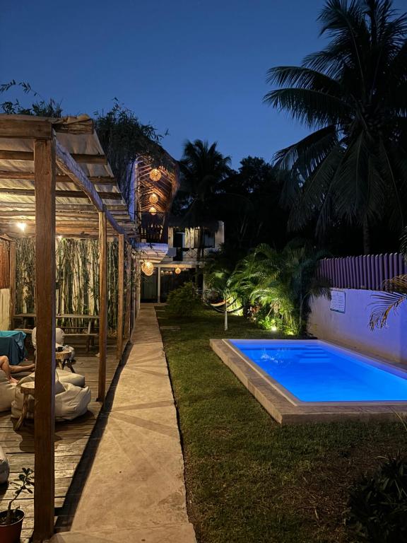 un patio trasero con piscina por la noche en Casa Delia Hotel Downtown en Bacalar
