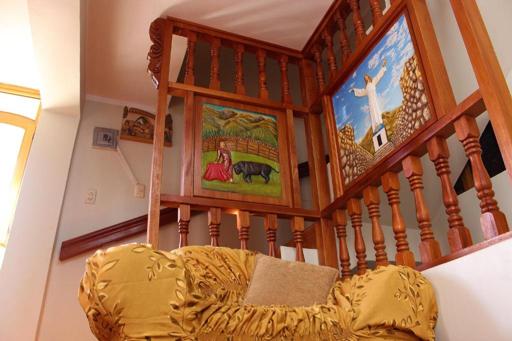 una escalera con una silla y un cuadro en la pared en HOTEL SÚMAQ PUÑUY, en Yungay