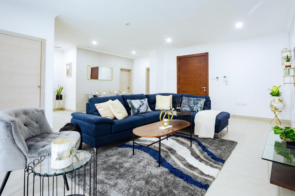 ein Wohnzimmer mit einem blauen Sofa und einem Tisch in der Unterkunft Incredible 2 Bedroom Space Available in Accra